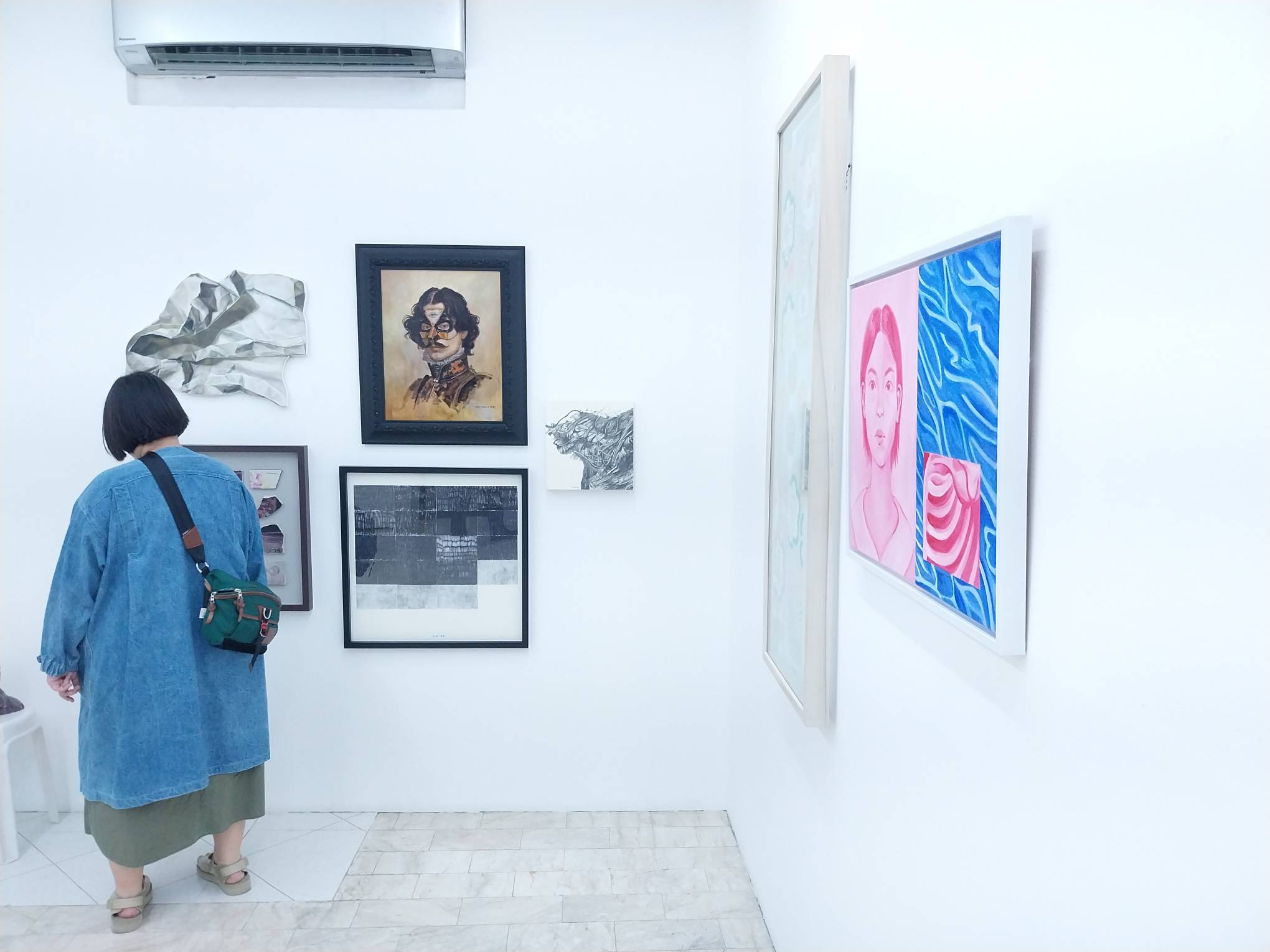 A person viewing some of the works for "On the Self." Photo by Elle Yap.