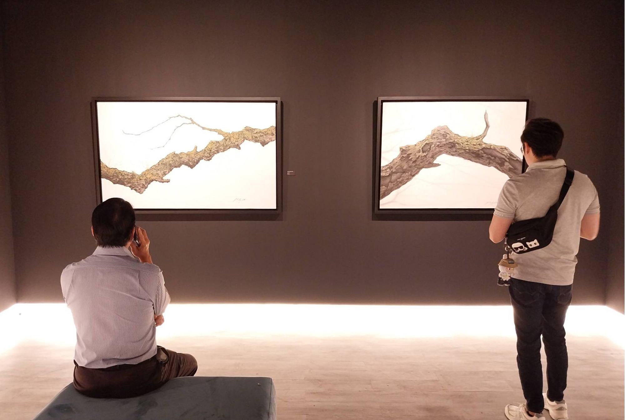 Two people looking at the paintings of 