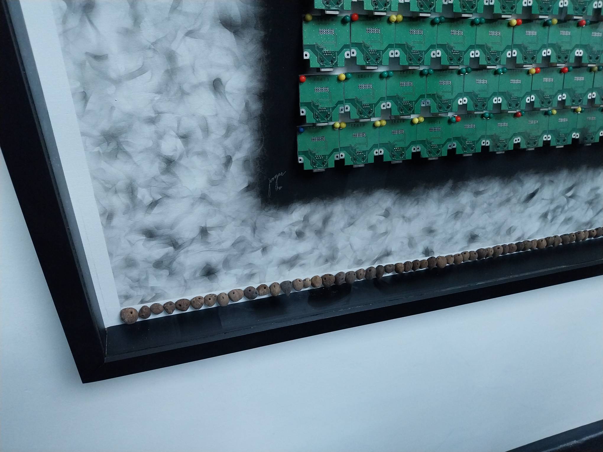 Close up of a microchip, soot, and seed work.