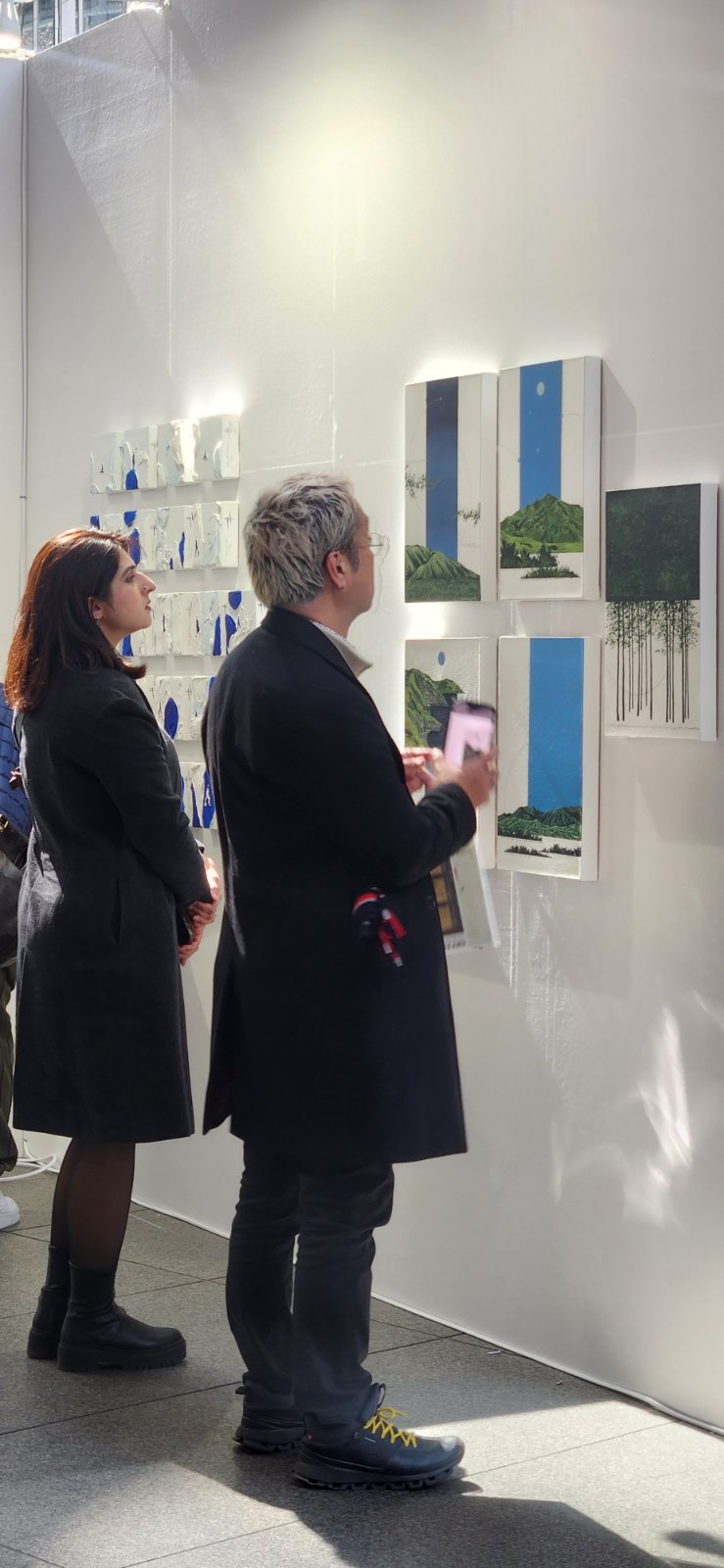 Visitors of Art Fair Tokyo looking at Jem Magbanua's paintings exhibited by Galerie Stephanie.