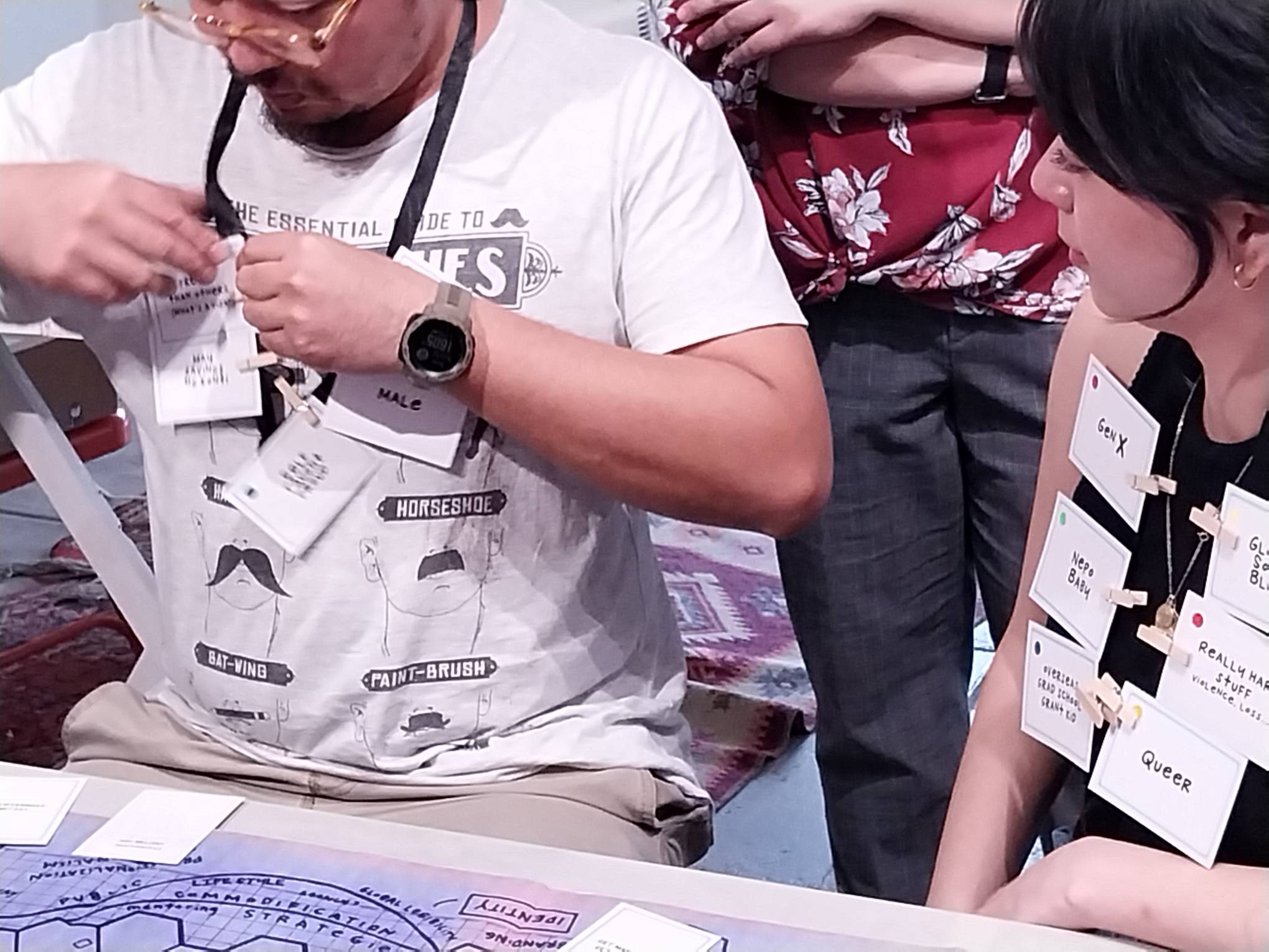 Players pinning their character tropes for the board game "Stakeholding."