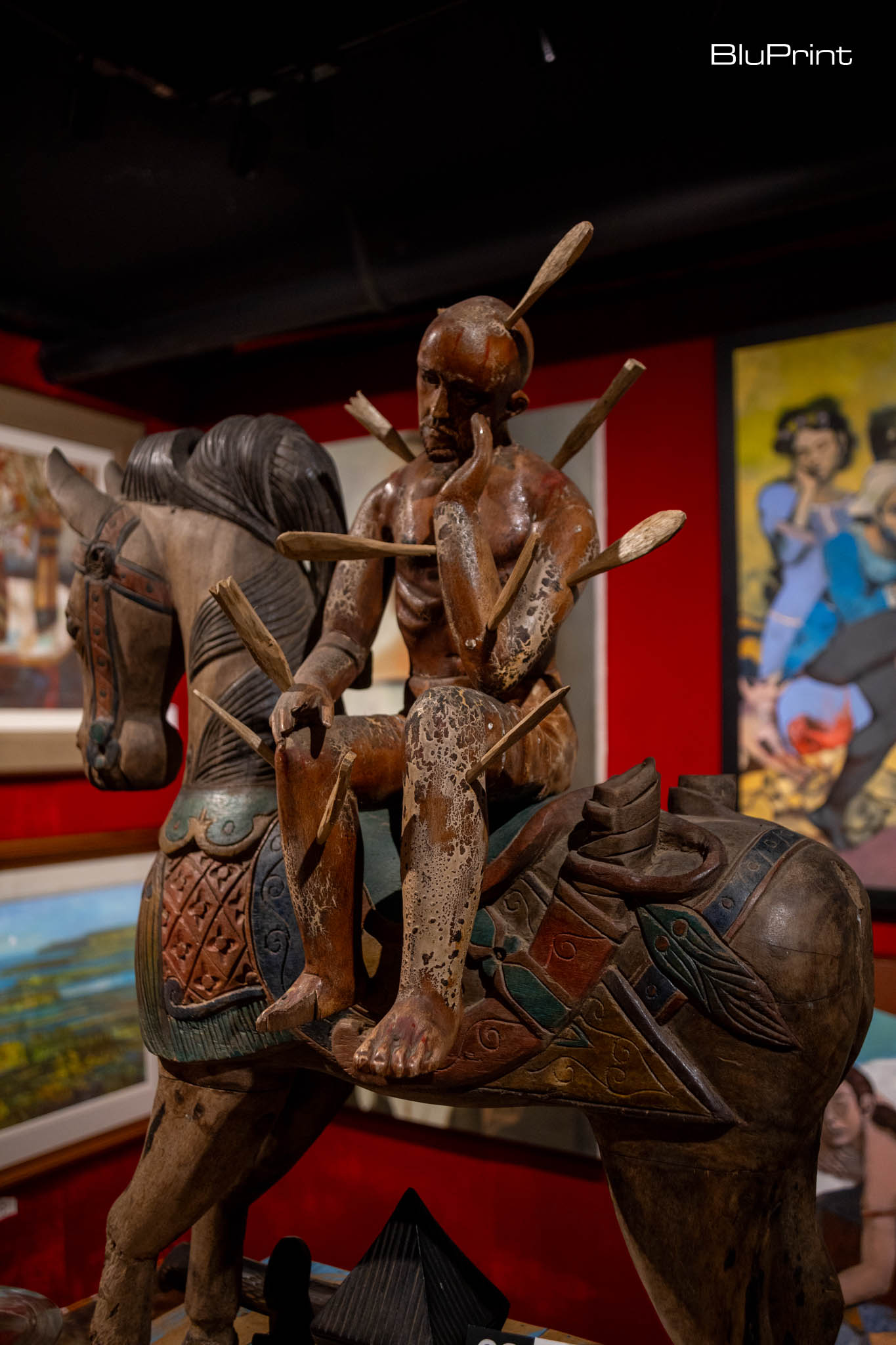Wood statue of a man on a horse.