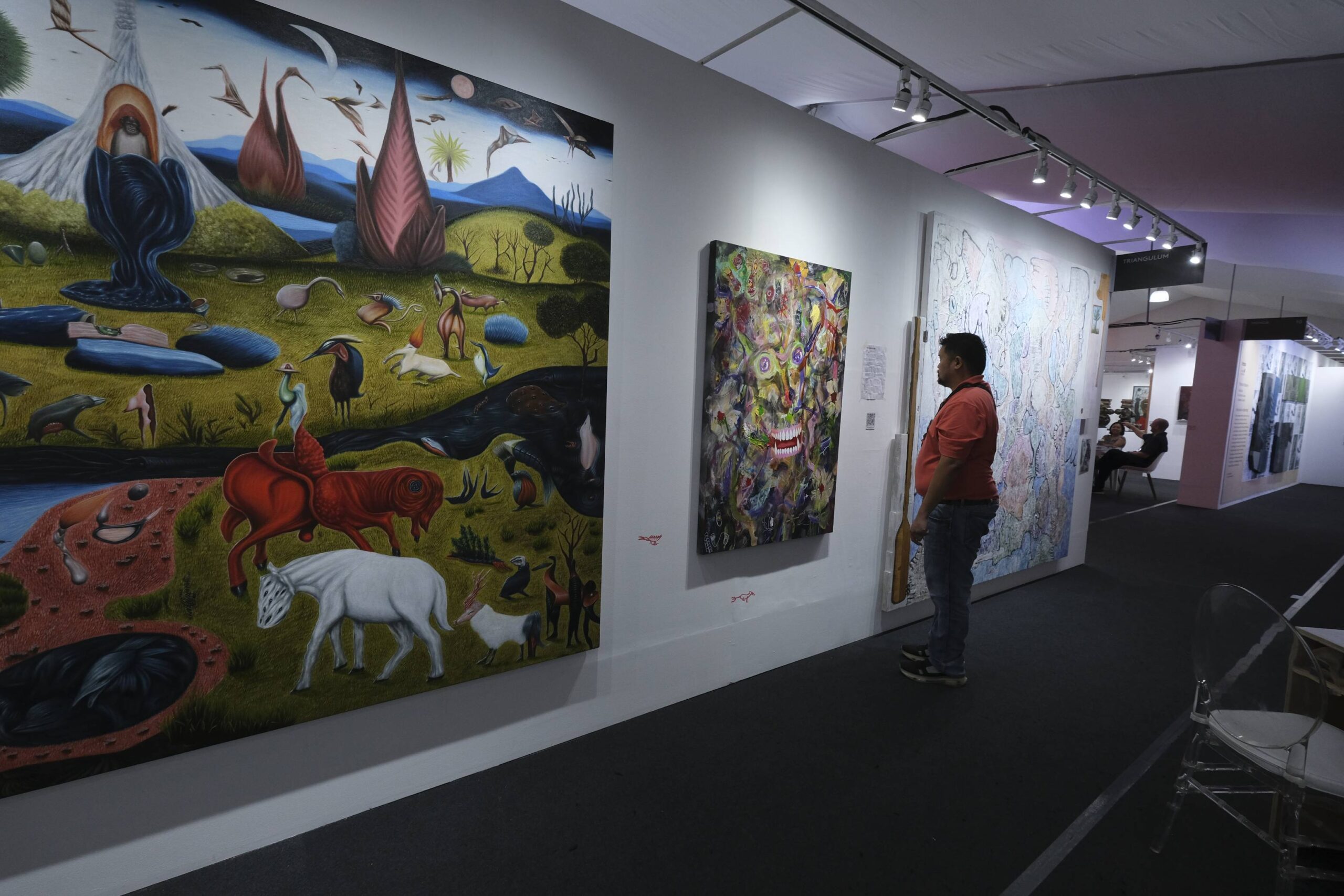 Spectator viewing an exhibit at Art Fair Philippines.