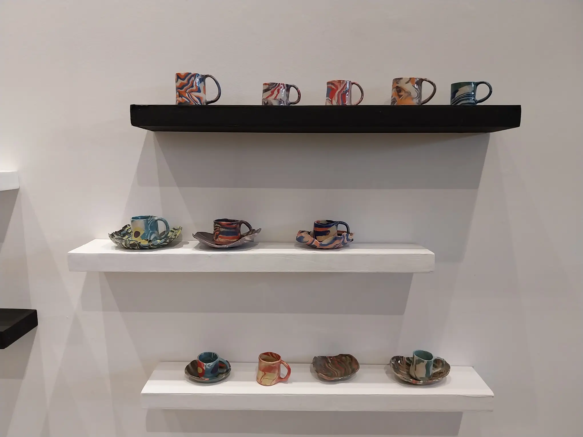 Three shelves of works by Winnie Go.