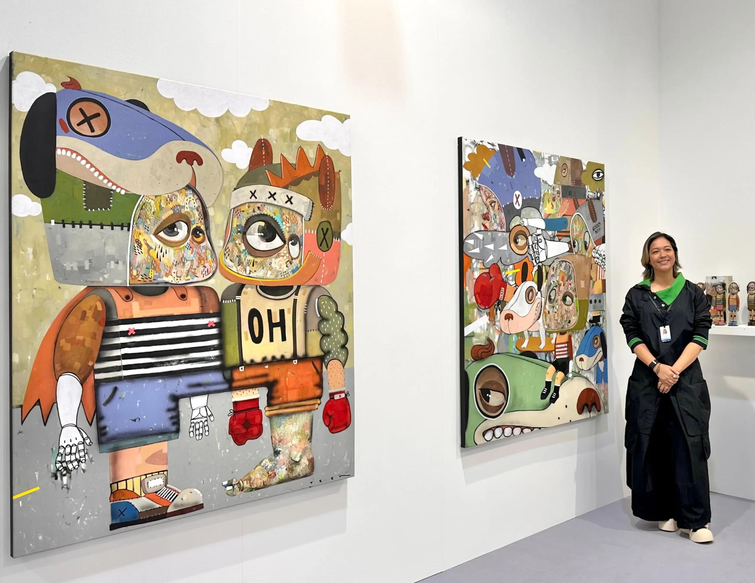 Gaby dela Merced next to paintings by Reen Cabrera.