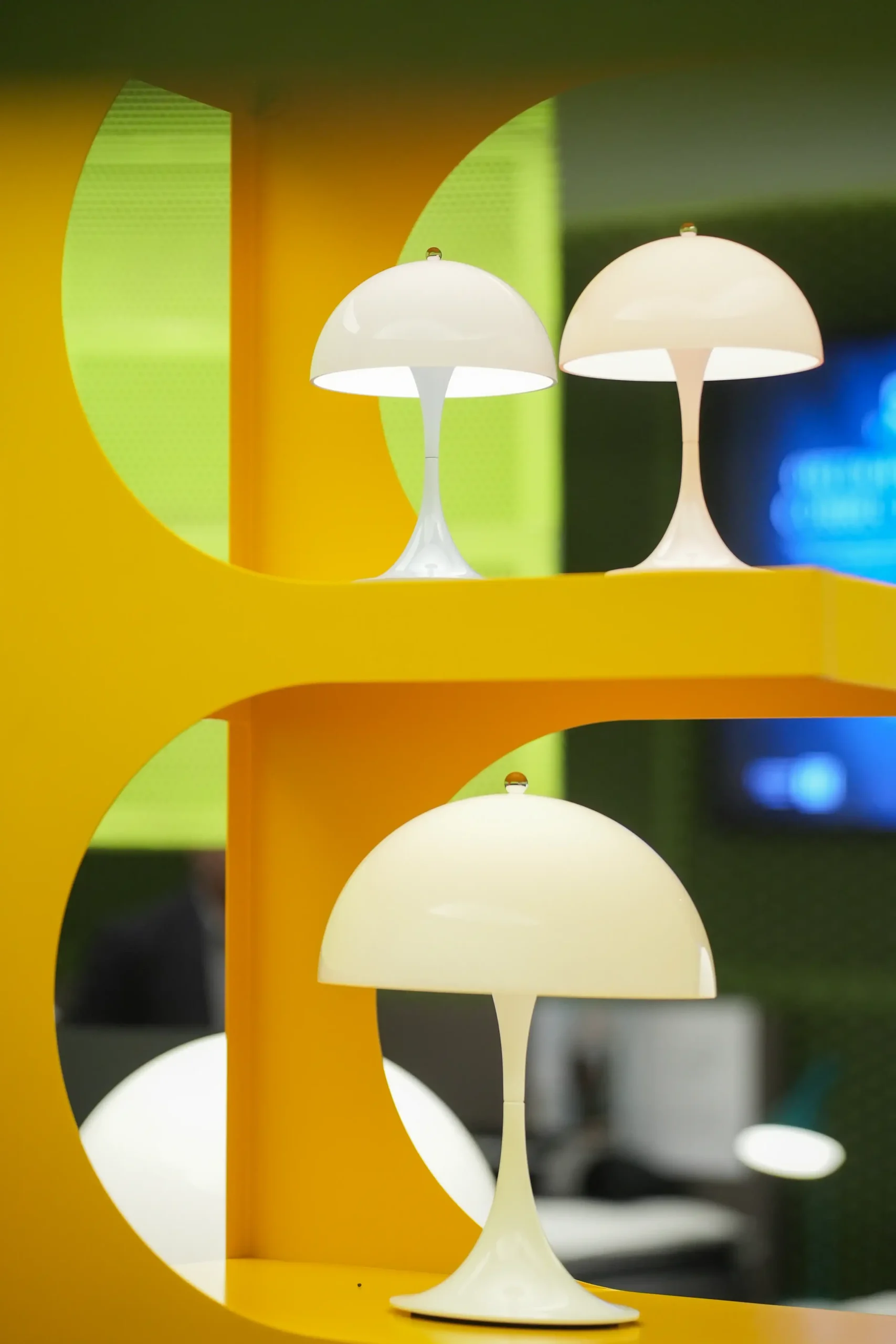 Panthella 160 Portable lamps on an orange display shelf.