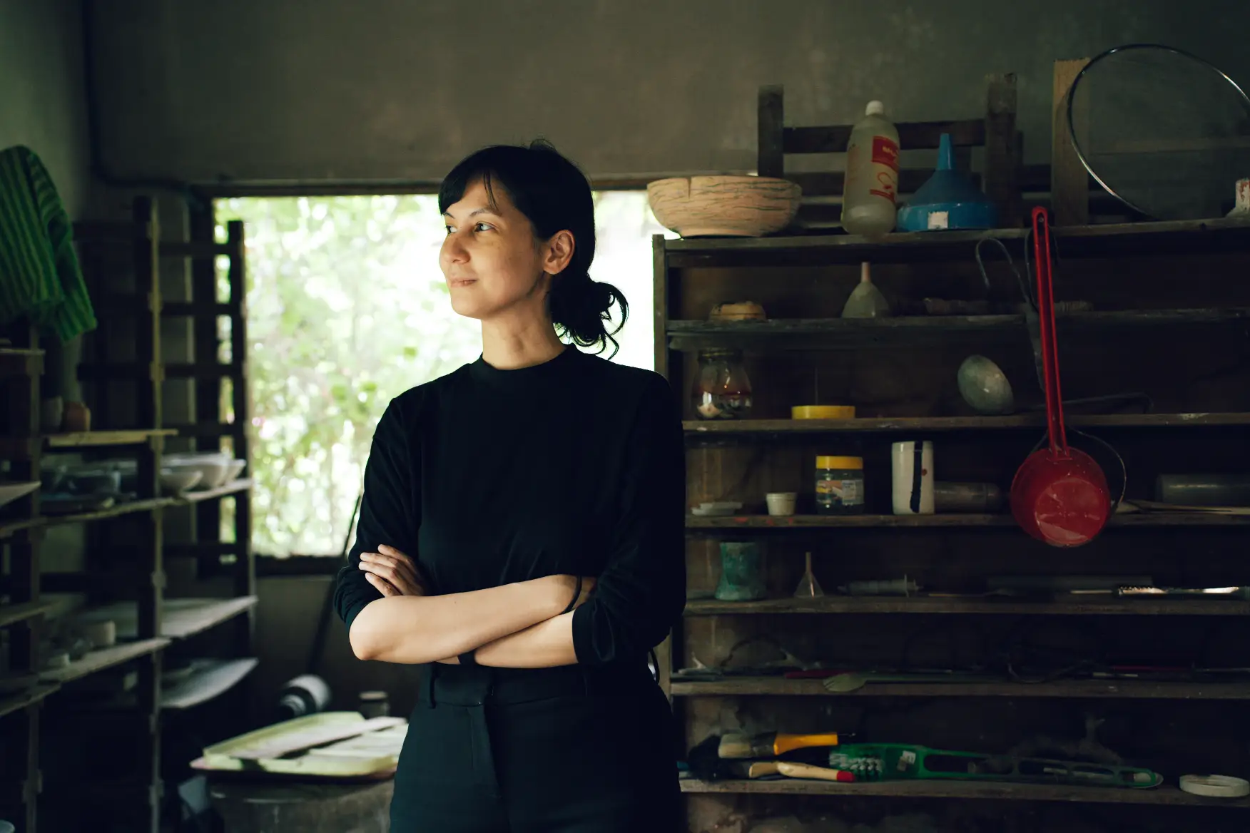 Artist Hanna Pettyjohn looking contemplatively out a window.