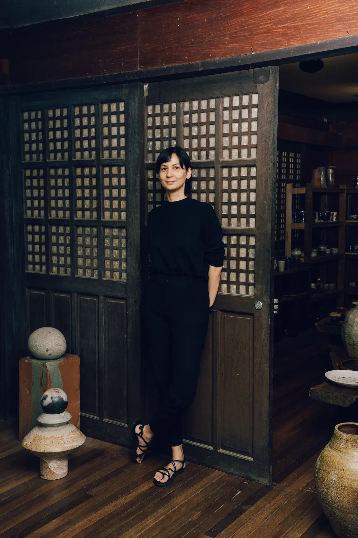Artist Hanna Pettyjohn posing with her back behind a wall.