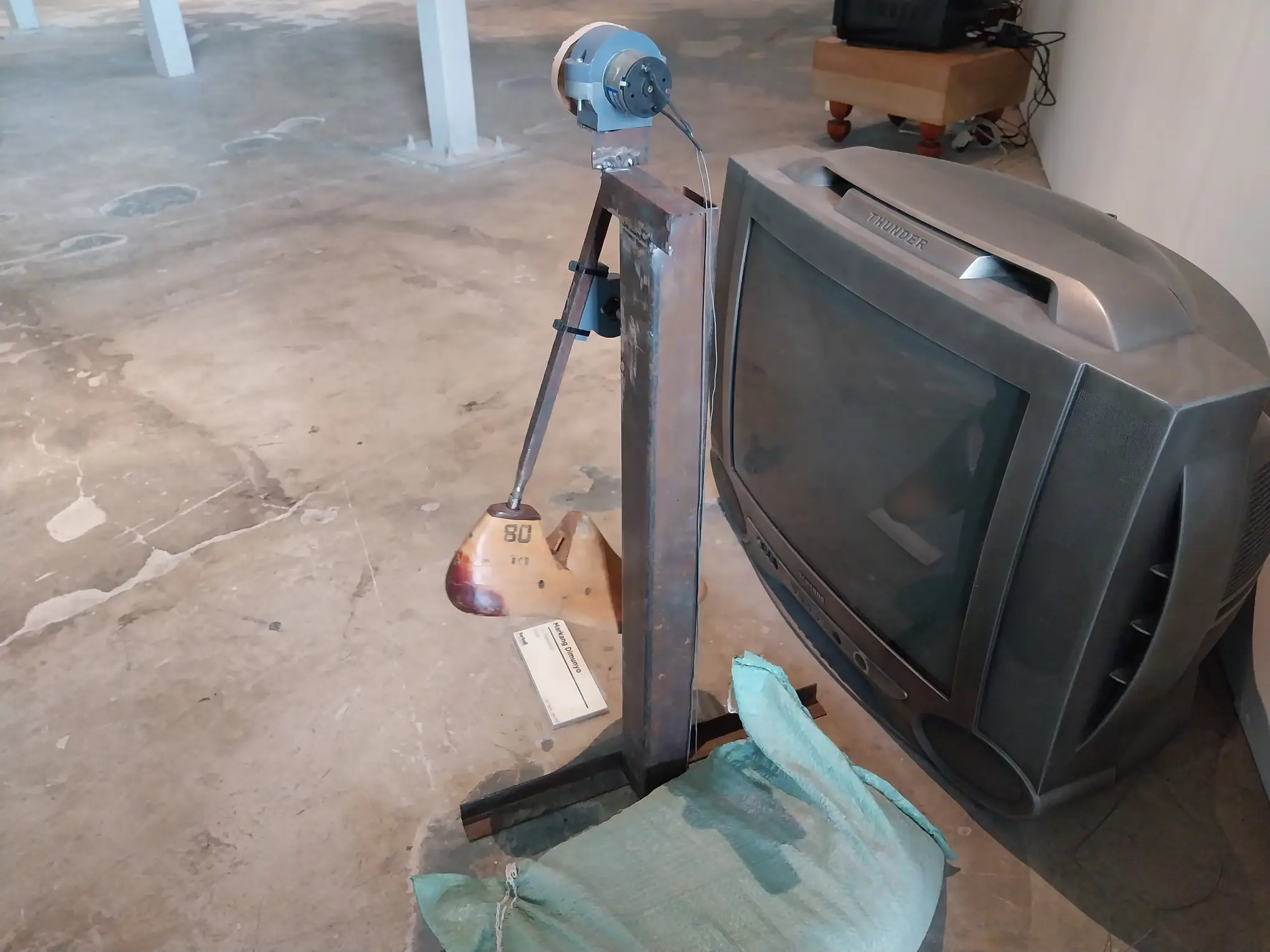 A television being kicked by a mechanical foot at "furball ex machina."