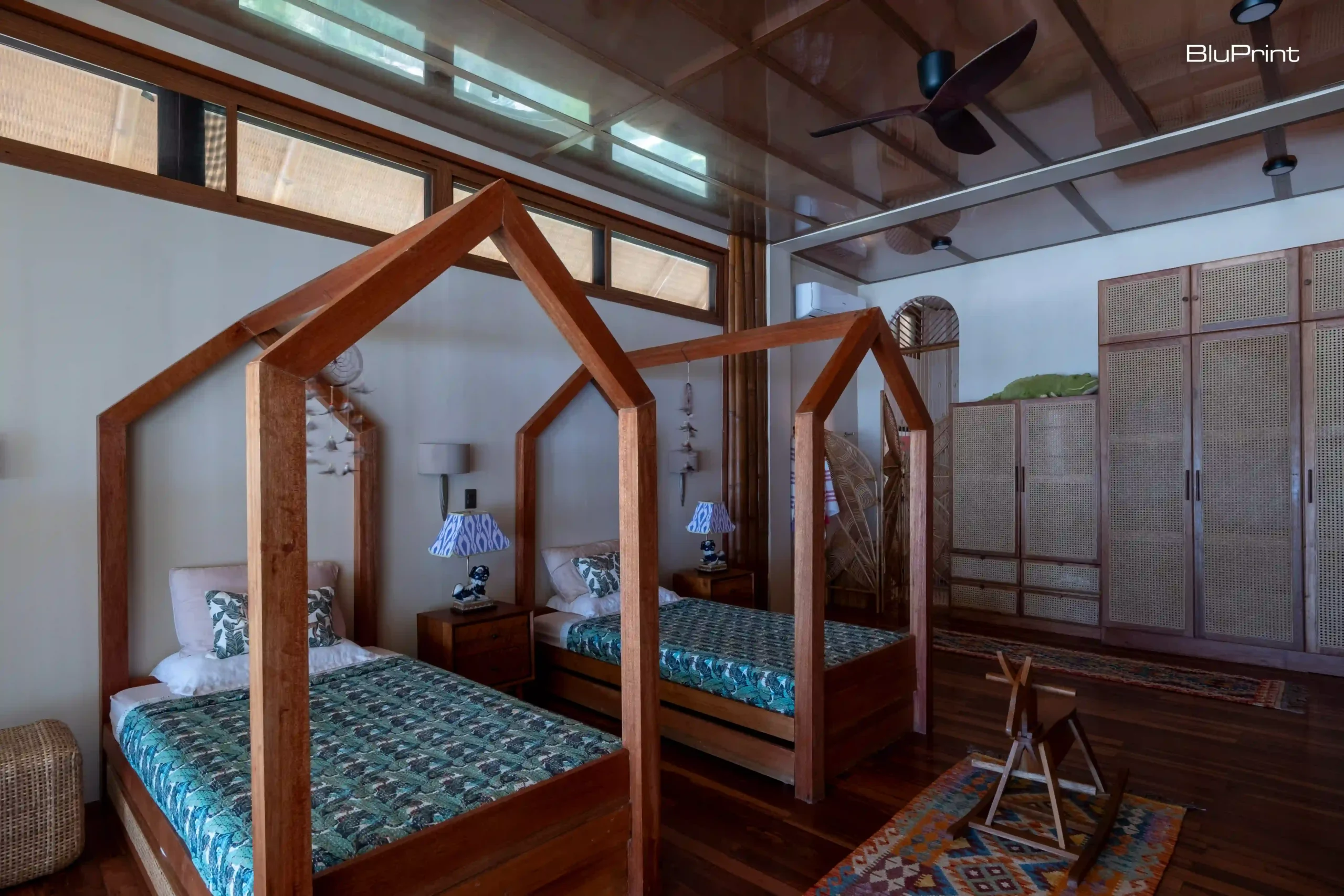 A kiddi room with wooden bedposts shaped like houses.