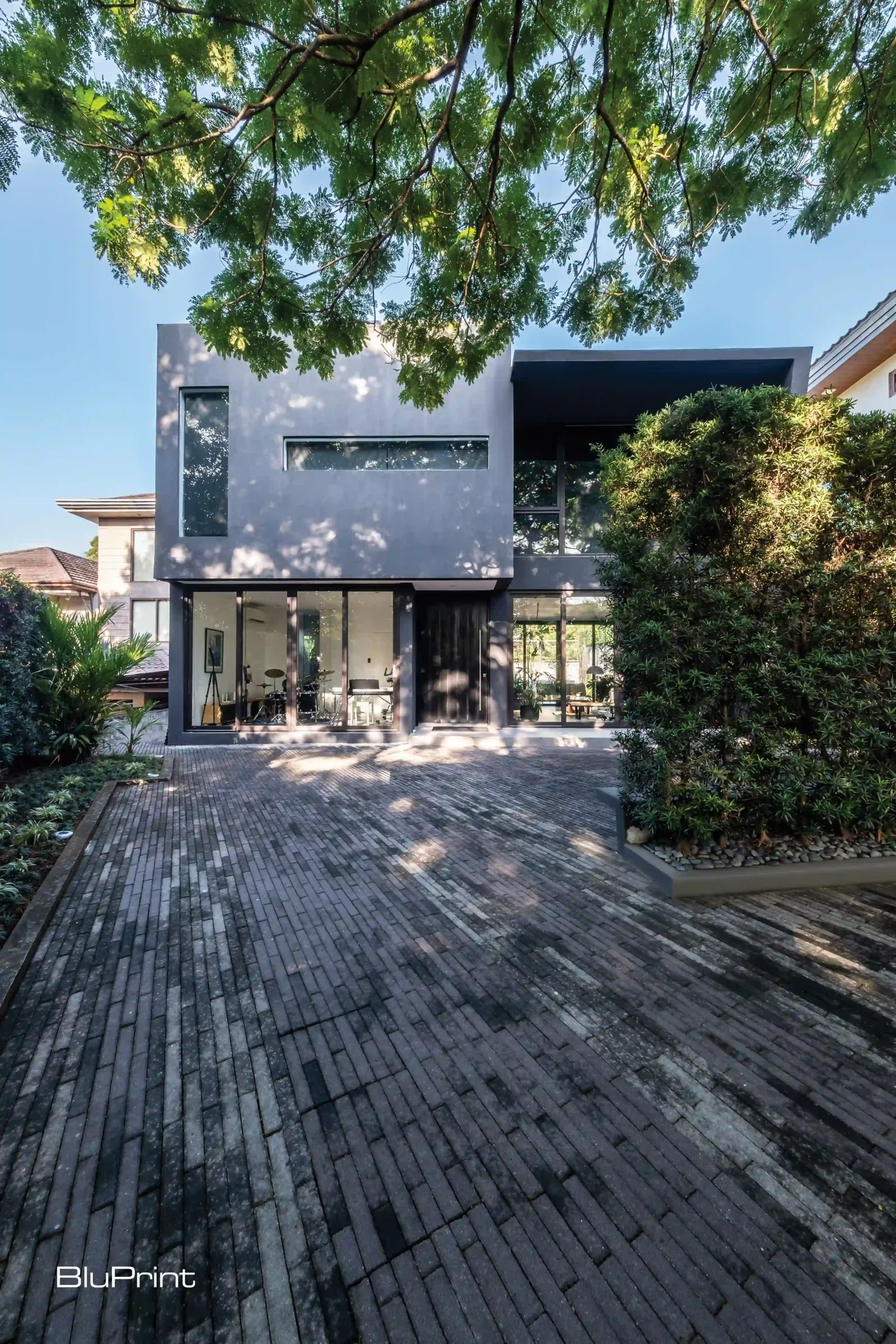 Descending House by Micaela Benedicto cuts a striking figure, its angular black form standing against the greenery.