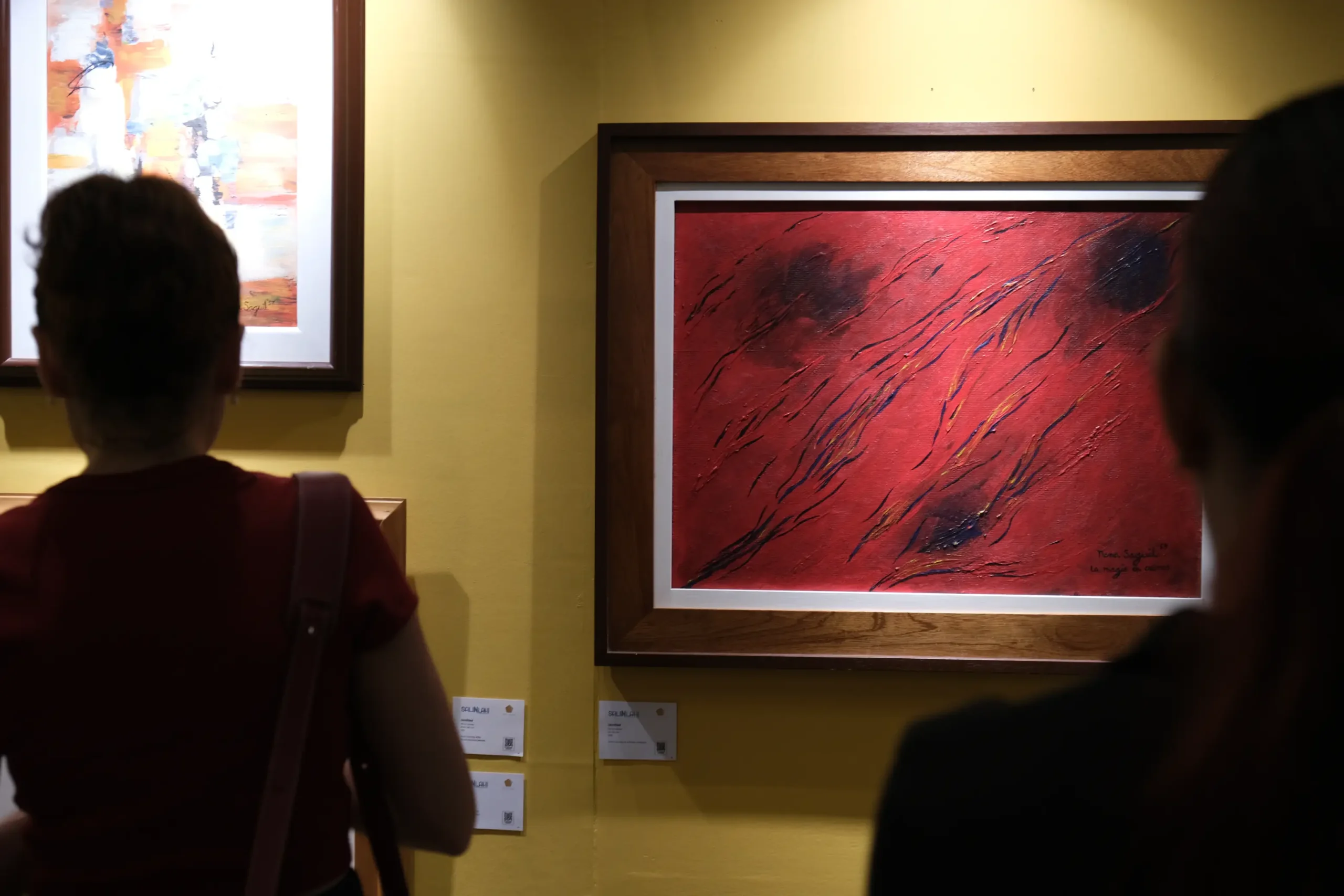 Visitors looking at artwork by Nena Saguil for "Salinlahi."