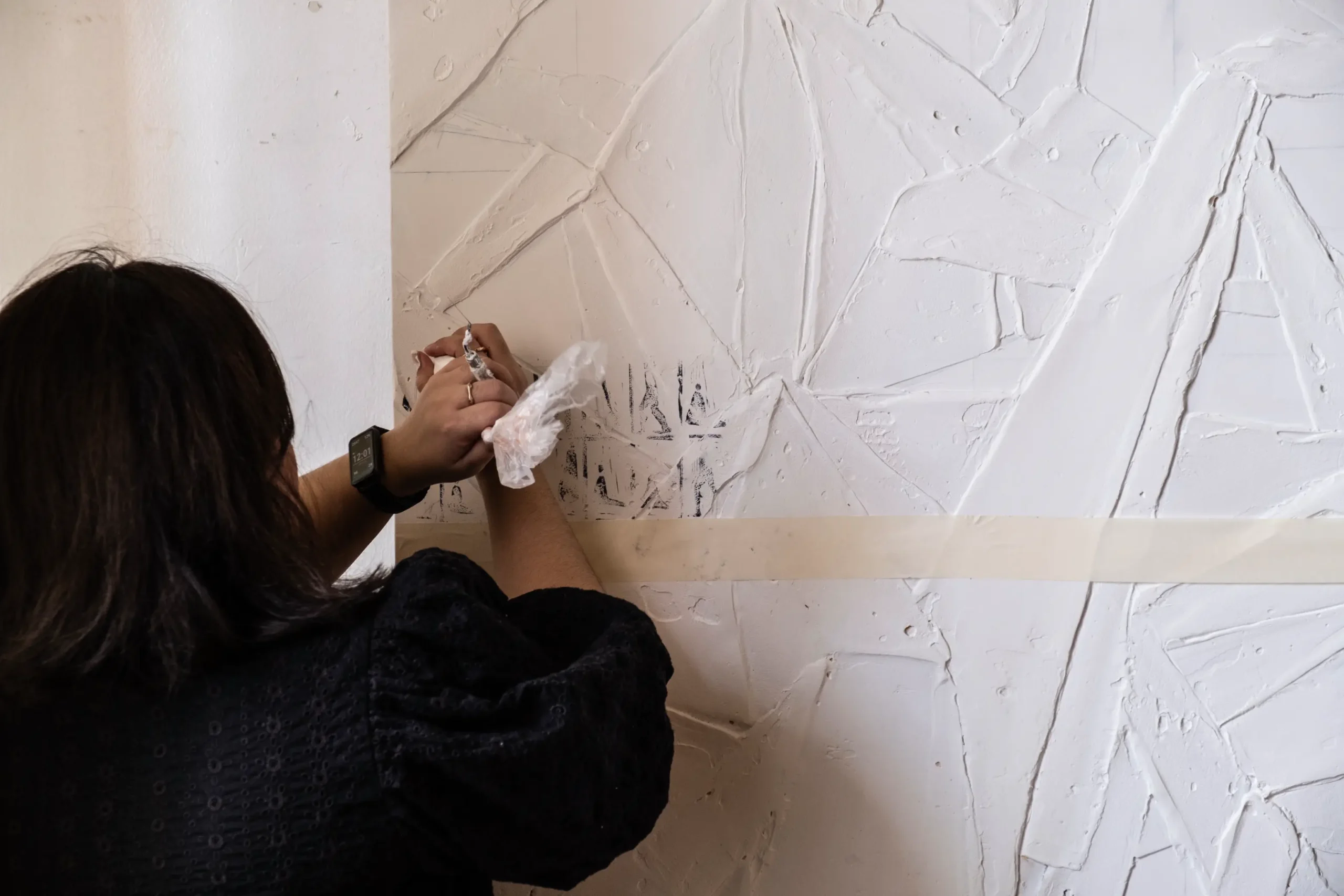 The artist at work, adding plaster to the work.