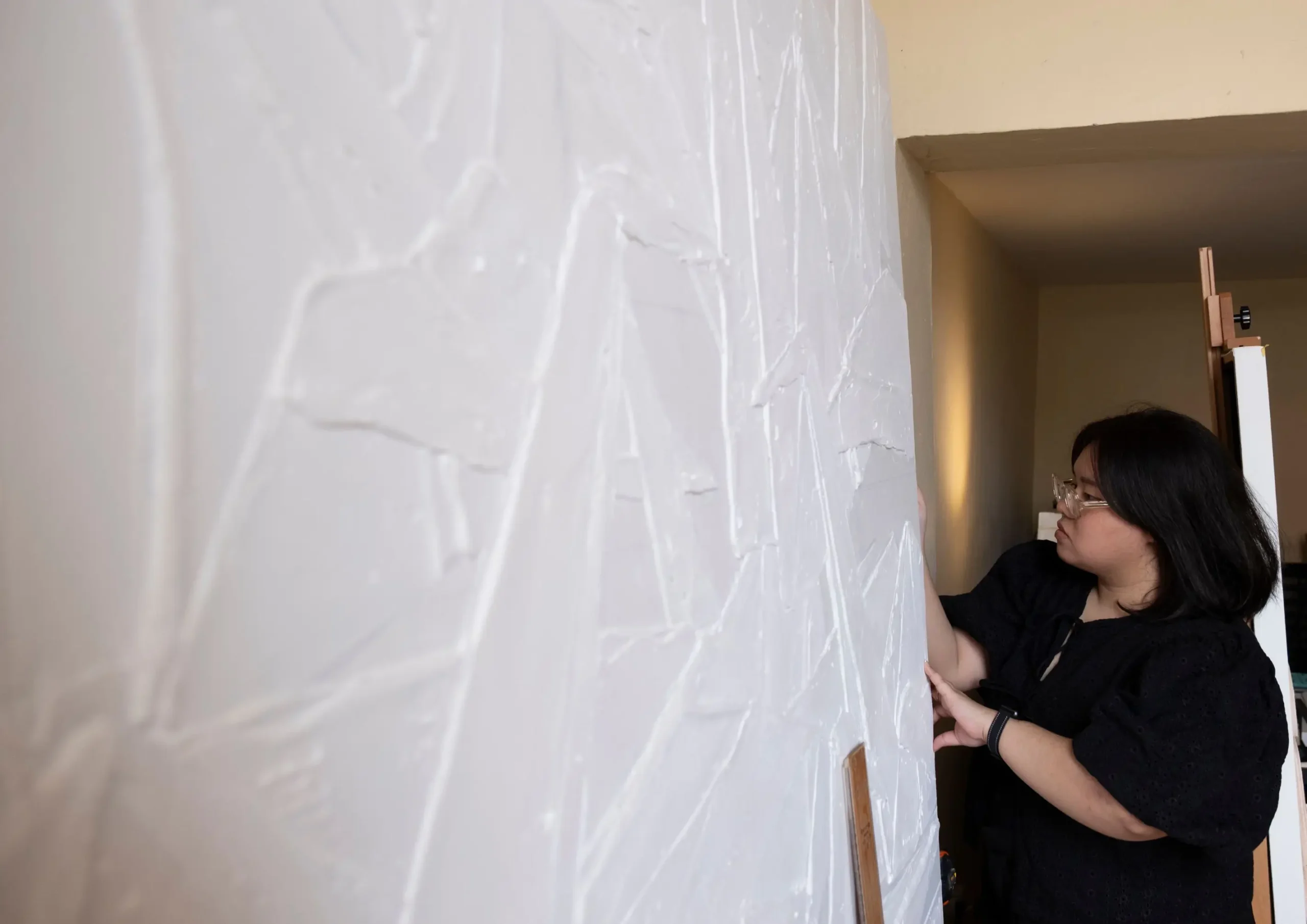 Thea Quiachon at work, with a blank canvas she is working on.