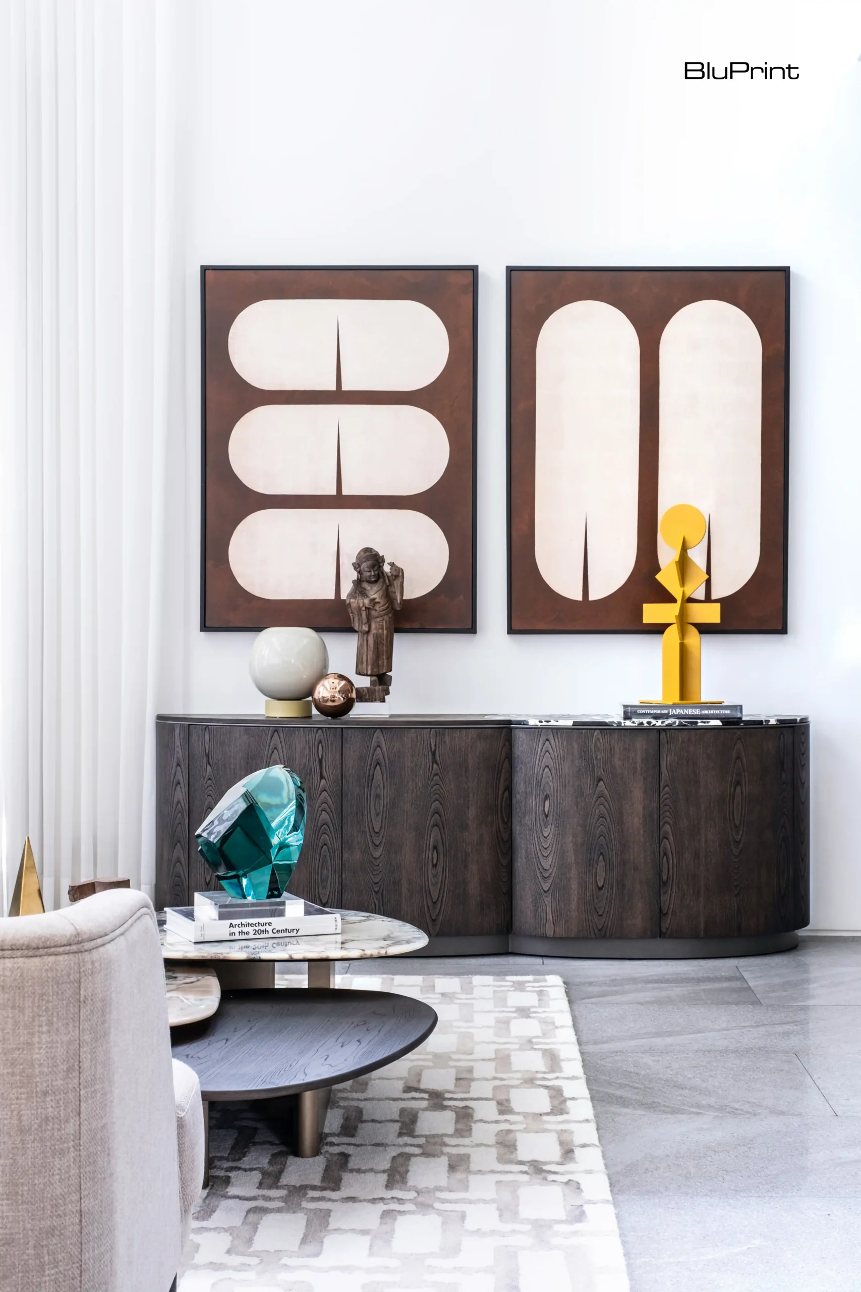 The living room, with the Jones Sideboard and Yves Center Table from Taylor Living by Casa Bella, utilizes sculptures by National Artist Arturo Luz and Ramon Orlina to match the calm sophisticated interior.