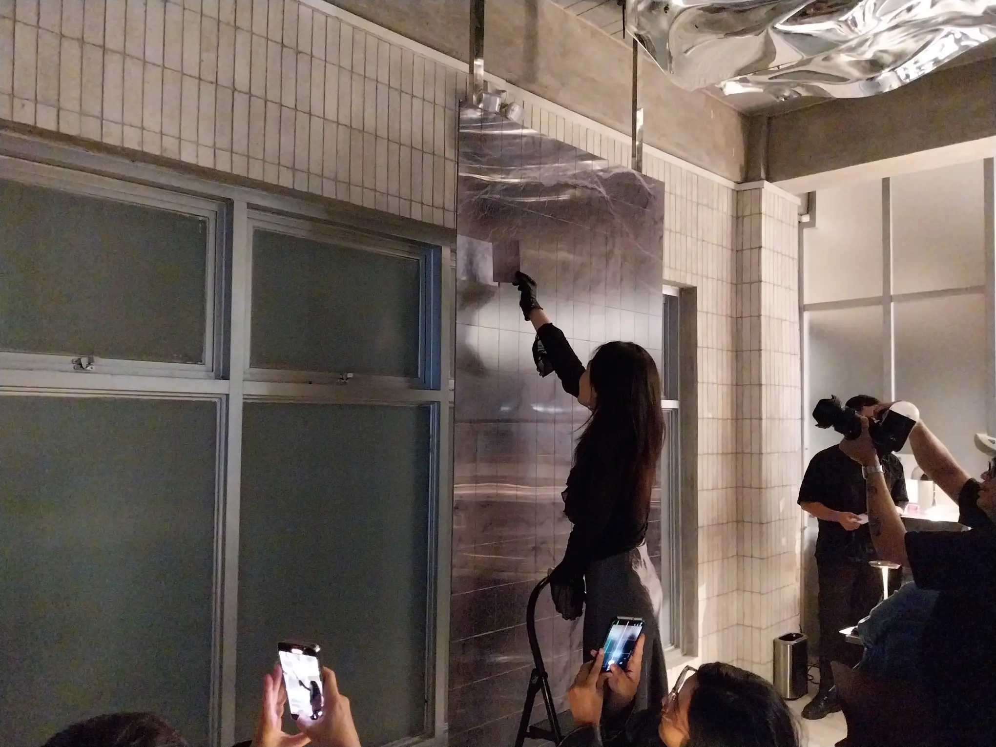 Celine Lee taking out one of the lenticular prints from "A Mass."