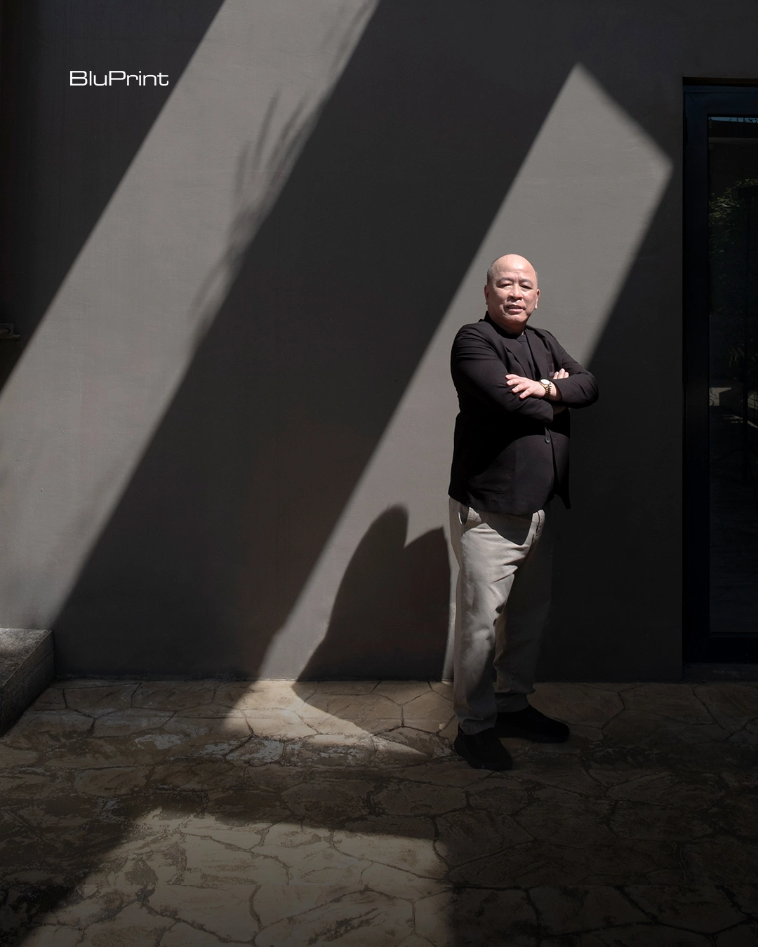 Arch. Jose Siao Ling of JSLA Architects standing with arms crossed against a concrete wall in angled light.